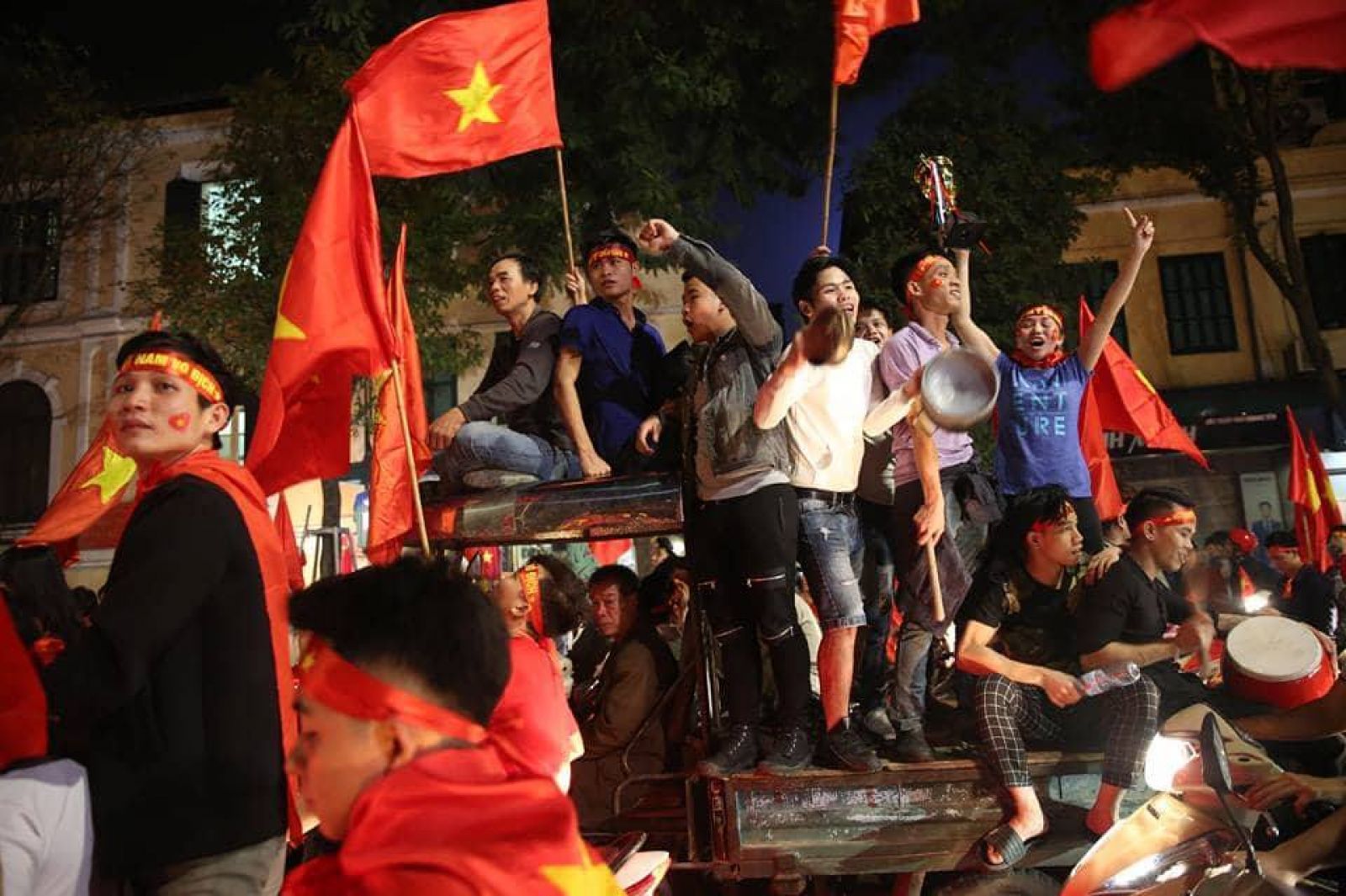 Một chiếc xe lam chở đầy CĐV với rất nhiều cờ