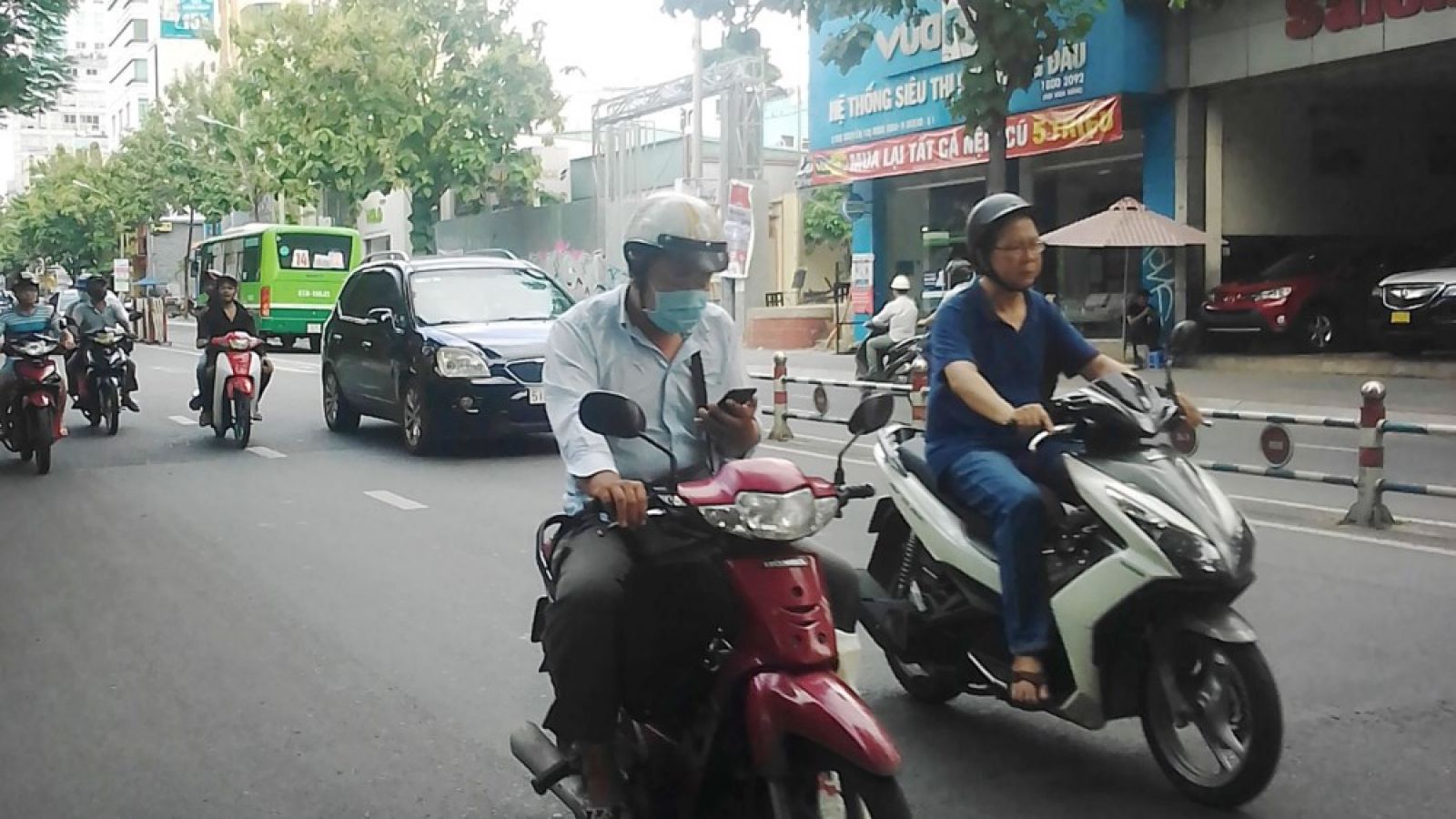 Lái xe máy và sử dụng điện thoại là thói quen của nhiều người Việt Nam