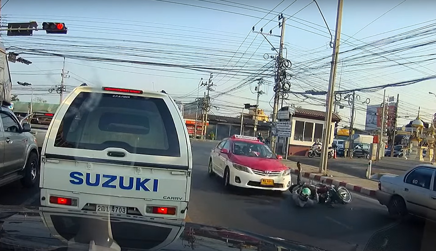 Tài xế taxi màu trắng hồng phanh nhưng vẫn đâm vào người lái xe máy đã ngã ra đường